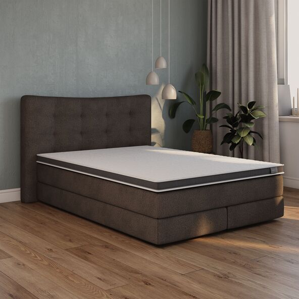 Matratzen Topper Luxe mit Gel Active Schaum ausgerollt auf einem Bett, weiße Oberfläche mit erkennbarer Struktur und bläulichen Gel-Einschlüssen.