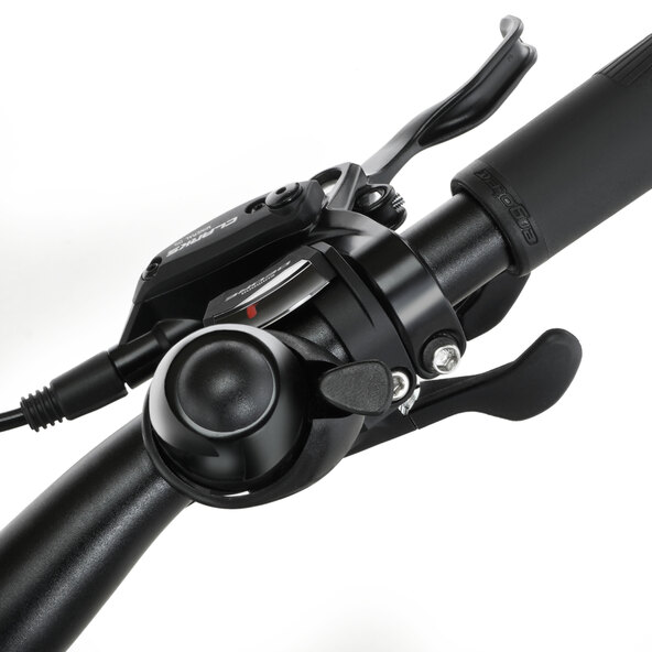 Silberfarbenes Trekking E-Bike mit Diamantrahmen, Gepäckträger, Schutzblechen und gefederter Gabel steht auf einem hellen Untergrund. Fokus liegt auf der Seite und den Komponenten.