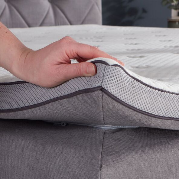 Helles, lichtgraues Boxspringbett Premium in der Größe 180 x 200 cm mit hohem Kopfteil und dezenten Füßen, fotografiert vor neutralem Hintergrund.