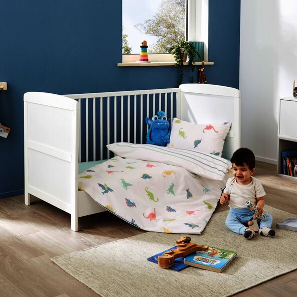 Bettwäsche-Set Dino: Helle Perkal-Bettwäsche mit Dinosaurier-Motiven in Blau-, Grün- und Gelbtönen, freundliches Design für Kleinkinder.
