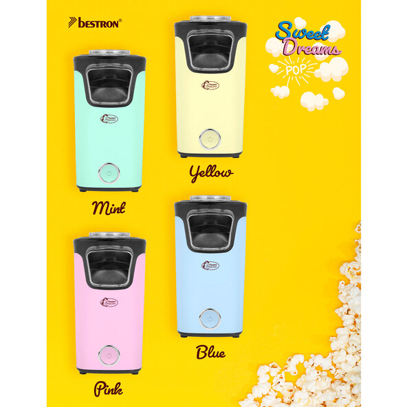 Pinke Popcornmaschine im Retro-Design mit transparentem Behälter und seitlichen Lüftungsschlitzen. Ein Messbecher liegt daneben.