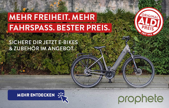 Fahrrad steht vor einer Hecke, Prophete Logo daneben
