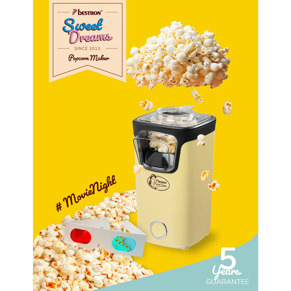 Gelbe Popcornmaschine mit transparentem Behälter und schwarzem Deckel auf einer weißen Oberfläche. Popcorn ist im Behälter sichtbar.