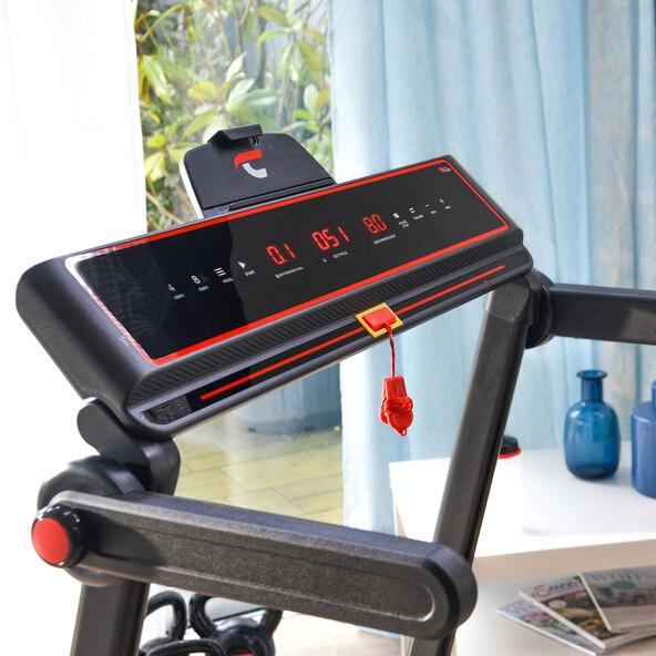 Laufband TM, frontal aufgenommen, mit LCD-Display, Bedienelementen und Haltegriffen, vor hellem Hintergrund.