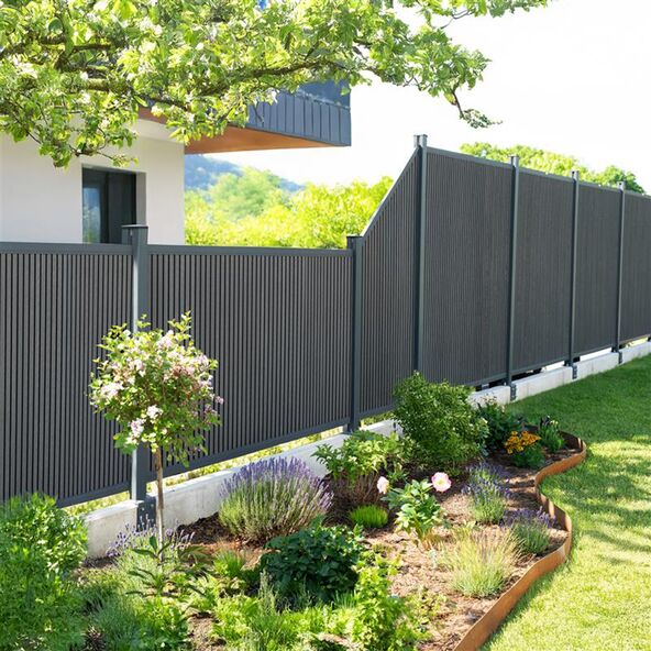 Ein CALLADO Premium Zaunpfosten, der einen Garten abgrenzt.