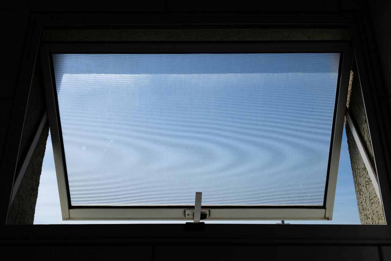 Großes Fenster auf Kipp mit Blick auf den freien blauen Himmel.