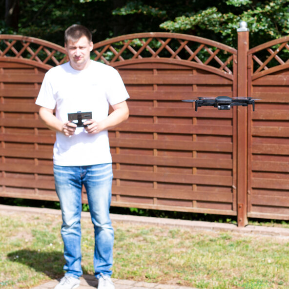 Draufsicht einer grauen Drohne mit vier Rotoren vor hellem Hintergrund. Das Produkt Drohne WIFI ist mittig platziert und gut ausgeleuchtet.