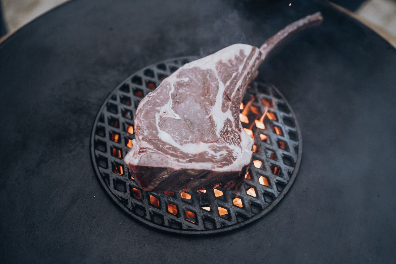 Ein rohes Steak liegt auf dem Grill.