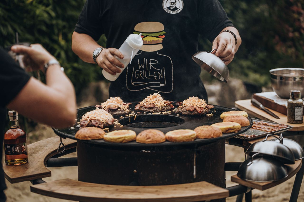 Die weiteren Burger Zutaten werden auf dem Grill gegeben.