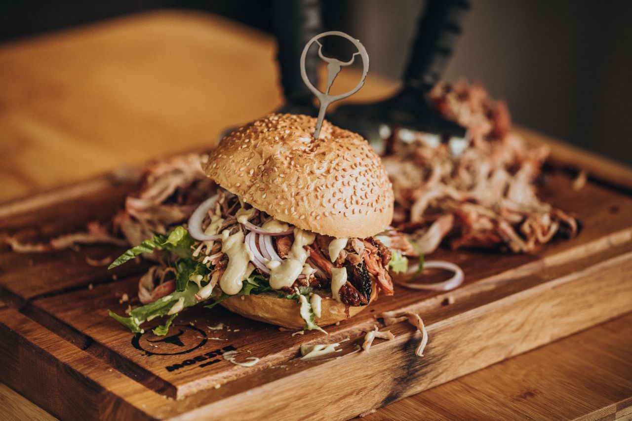 Burger mit Pulled Pork auf Holzschneidebrett.