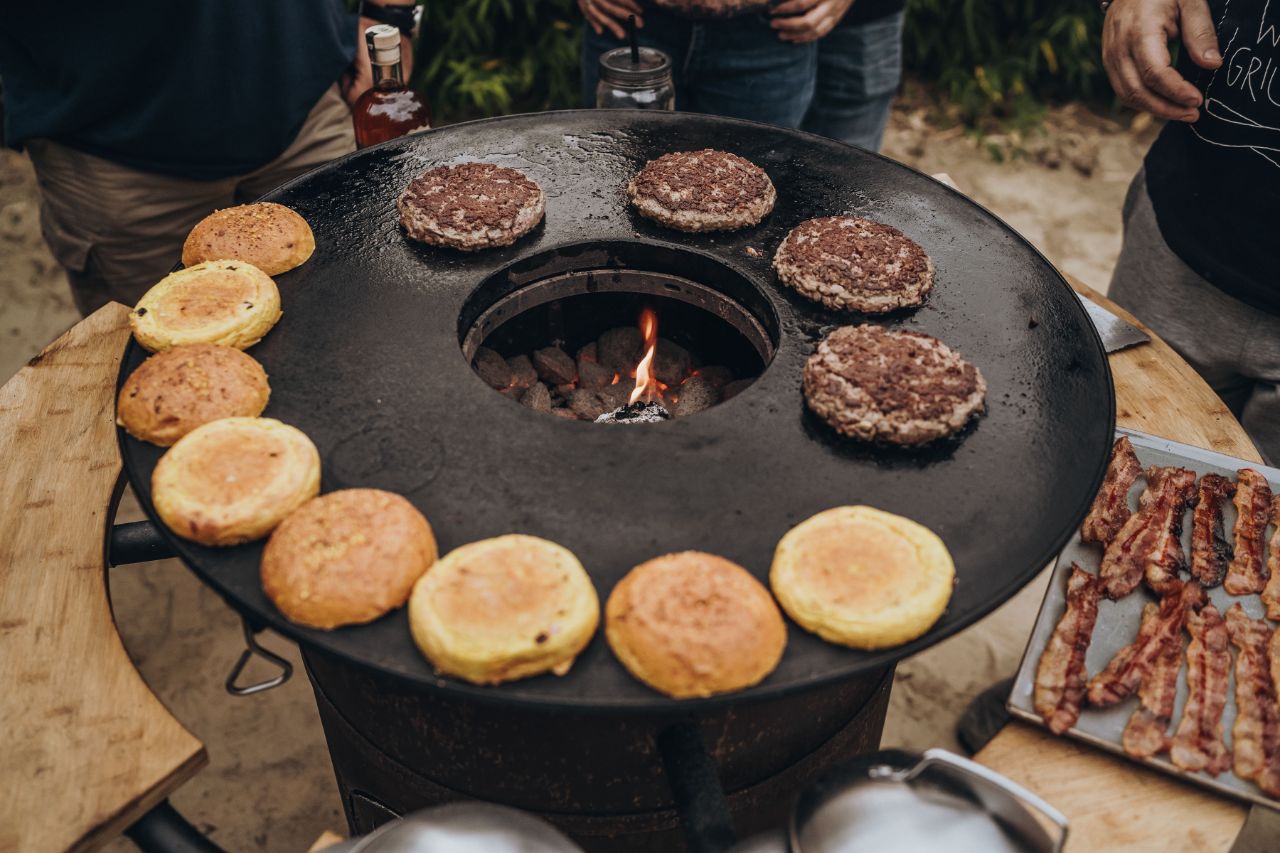 Patties und Burger werden auf einem Moesta Grill angebraten.