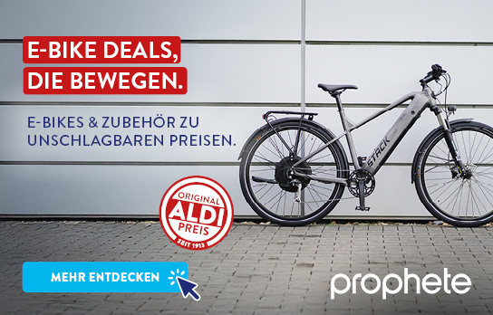 E-Bike steht vor weißer Wand, Prophete Logo daneben