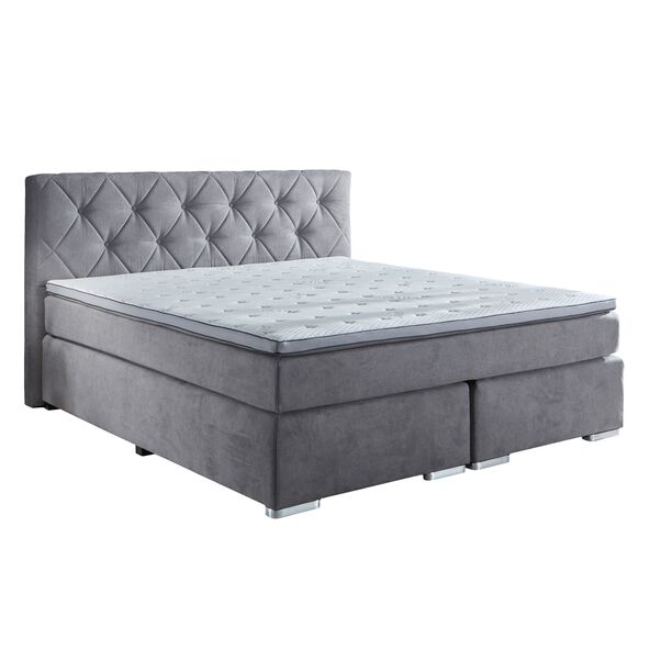 Hellgraues Boxspringbett, bestehend aus Matratze und Topper auf einem gefederten Untergestell. Das Bett ist mit einem hohen, gesteppten Kopfteil ausgestattet und steht auf dunklen Füßen.