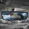 Ein montierter Rückspiegel mit integriertem Display, der das Bild einer Rückfahrkamera anzeigt. Das Display zeigt eine klare Ansicht des Bereichs hinter dem Fahrzeug.