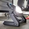 LED Arbeitsstrahler leuchtet hell. Stabiles, schwarzes Gehäuse mit gelbem Griff und Standfuß. Kabelanschluss hinten sichtbar. Ideal für Werkstatt oder Baustelle.