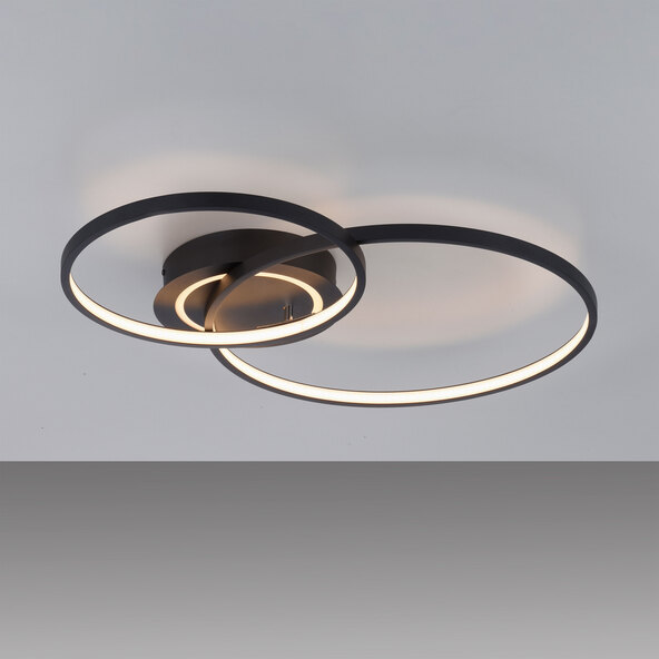 Schwarze, runde LED-Deckenleuchte ASMINA mit einem flachen, geometrischen Design. Das Licht scheint diffus und gleichmäßig. Der Hintergrund ist neutral weiß.