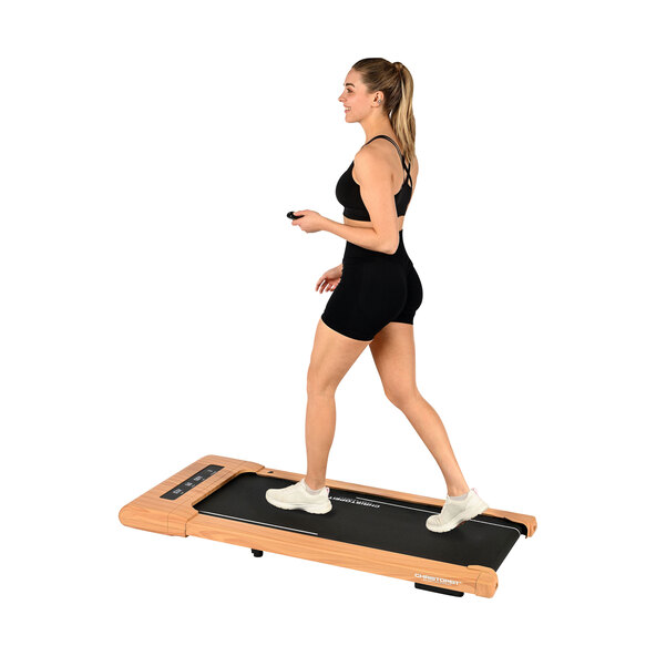 Walking Pad in Holzoptik auf hellem Boden. Das Laufband ist flach, zusammenklappbar und hat eine dunkle Bedieneinheit.
