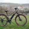 Dunkelblaues Stack Sport E-SUV Bike mit 29-Zoll-Reifen, sichtbarem Akku am Unterrohr und Federgabel, abgebildet vor neutralem Hintergrund.