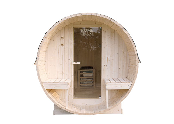 Freistehendes, helles Holz-Saunafass mit Panoramafenster und kleinem Vorraum im Garten, umgeben von Rasen und Bäumen.