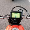 Motorrad-Navi mit Touchscreen auf Motorradlenker montiert. Das Display zeigt eine Kartenansicht.