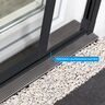 Anthrazitfarbene Insektenschutz-Doppelschiebetür aus Aluminium mit Laufschiene, frontal aufgenommen, zeigt geöffnete und geschlossene Türhälften im Wohnraum.