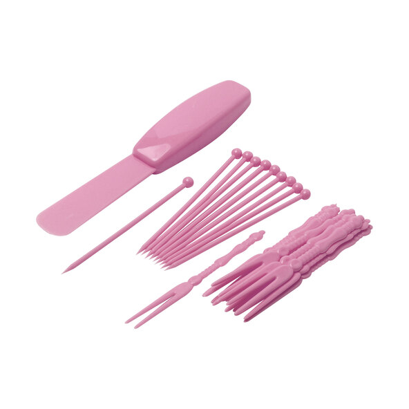 Pinkfarbenes Mini Schoko-Fondue-Set mit einem kleinen Topf auf einem Sockel, Gabeln und Schokoladenstückchen sind abgebildet.