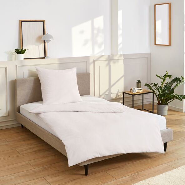 Set von weißer Bettwäsche ausgebreitet auf einem Bett.
